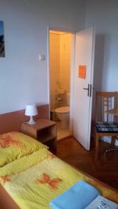 1 dormitorio con 1 cama y baño con aseo en Penzion Villa Gerlach, en Nový Smokovec