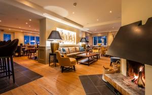 a living room with a fireplace and a couch at Hotel Birke - Appartments Waldesruh in Kiel