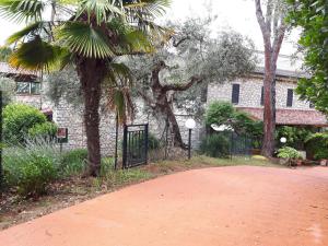 a gate in front of a building with a palm tree at ELIO e DONY in Passignano sul Trasimeno