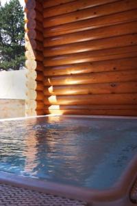 a swimming pool with a wooden wall and water at Chalet Ana in Les Angles