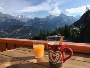 a cup of orange juice sitting on a table with a view at Les Melezets 1 in Valfréjus