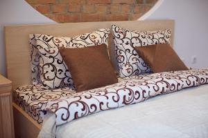 a bed with three pillows on top of it at Babylon Apartments On Dubenska Street in Rivne
