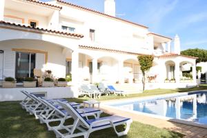 a villa with a swimming pool and lounge chairs at Casa Sol da Falesia in Albufeira