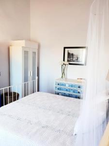 a bedroom with a white bed and a blue dresser at Casa do Avô Tó in Reguengos de Monsaraz