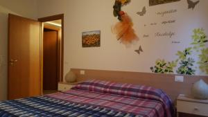 1 dormitorio con 1 cama con manta a cuadros en Borgo Rosia Holiday House en Rosia