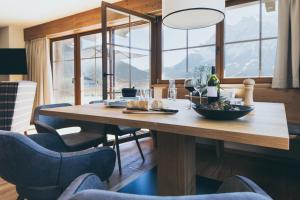 a dining room with a wooden table and chairs at PUR Suites & Chalets in Lermoos