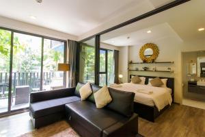 a bedroom with a bed and a couch in front of a window at The Deck Condominium Patong Beach in Patong Beach