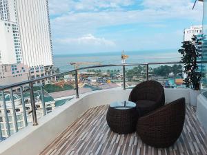 
a balcony overlooking a city with a view of the ocean at New Sun Hotel in Nha Trang

