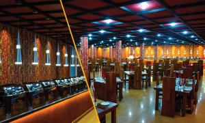 uma sala de jantar com mesas, cadeiras e luzes em The Queensburry City Hotel em Nuwara Eliya
