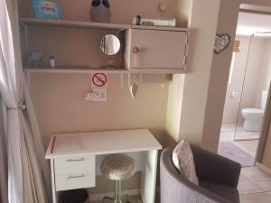 ケープタウンにあるThe Fairwayの小さな客室で、デスクと椅子が備わります。