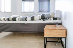 een bed in een kamer met een houten tafel bij Hotel Ikast in Ikast