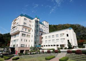 a large white building next to two other buildings at Blancart Misasa in Misasa