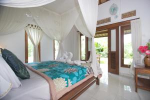 Giường trong phòng chung tại Telaga Homestay Ubud