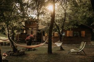 a hammock in front of a log cabin at Vackorkert in Sirok