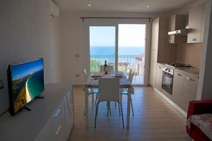 una cucina con tavolo da pranzo e vista sull'oceano di La Contessa Pool & Sea View a Santa Teresa di Gallura