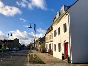 eine Straße mit einem weißen Gebäude und einer Straßenlaterne in der Unterkunft Werderapartment, FeWo und DZ in Werder