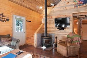 a living room with a fireplace in a log cabin at Moose in South Fork
