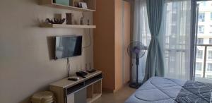 sypialnia z łóżkiem, telewizorem i oknem w obiekcie Eighty One Newport Boulevard w mieście Manila
