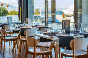プラタモナスにあるPorto Marine Hotelのテーブルと椅子、大きな窓のあるレストラン