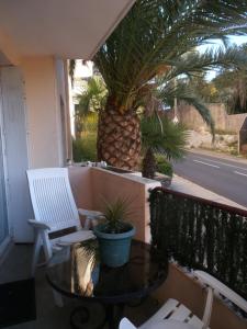 een tafel en stoelen op een balkon met een ananas bij Cosy Nîmes in Nîmes