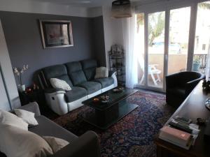 a living room with a couch and a table at Cosy Nîmes in Nîmes