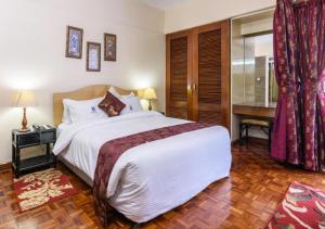 a bedroom with a large bed and a desk at Chester Hotel and Suites Nairobi, City Centre CBD in Nairobi