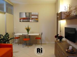 ein Wohnzimmer mit einem Tisch und einem TV in der Unterkunft Residenze Italia in Sesto San Giovanni