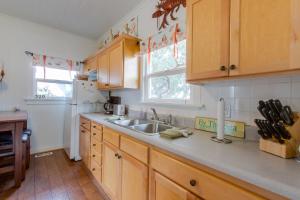 a kitchen with wooden cabinets and a sink and a refrigerator at Seaside Cottage in Seaside
