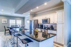 a kitchen with white cabinets and a island with bar stools at Pathway 14820 in Padre Island