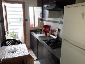 a small kitchen with a sink and a refrigerator at Appartement Adrar pour Famille in Agadir