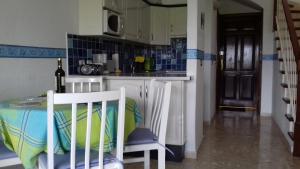 eine Küche mit einem Tisch und 2 Stühlen in einem Zimmer in der Unterkunft AMAZING SEASIDE DUPLEX IN THE GREEN SOUTH TENERIFE in San Miguel de Abona