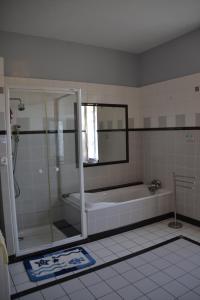 a bathroom with a shower and a bath tub at Gîte chez la Marie in Épinal +30 photos