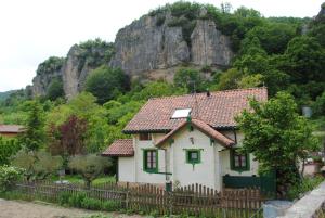 La Casita del Río في Sabando: بيت ابيض صغير وفيه سياج امام جبل