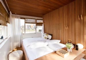 1 dormitorio con cama blanca y pared de madera en SWEETS - Buiksloterdraaibrug en Ámsterdam