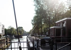 uma vista para um canal com uma cerca e um rio em SWEETS - Scharrebiersluis em Amsterdã
