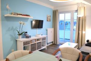 ein Wohnzimmer mit einem Fernseher an einer blauen Wand in der Unterkunft Haus Sonnenhof Bansin in Bansin