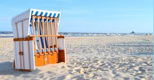 einen Strandkorb im Sand am Strand in der Unterkunft Haus Sonnenhof Bansin in Bansin