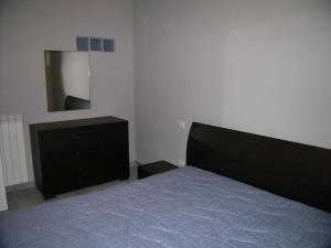 1 dormitorio con cama, tocador y espejo en Appartamento Ateleta via Colle Sisto, en Ateleta
