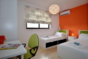 Cette chambre comprend deux lits, un bureau et une table. dans l'établissement City Living Suite Tk 3 Rm 3, à San Ġiljan