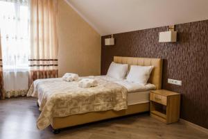 a bedroom with a bed with two stuffed animals on it at Hostynnyy Dvir in Stryi