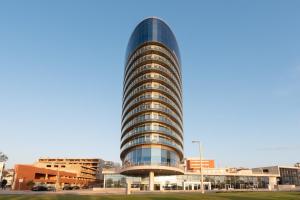 a tall glass building in a city at Eurostars Oasis Plaza in Figueira da Foz