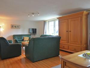 sala de estar con 2 sillas verdes y mesa en Holiday home in Sauerland with garden, en Schmallenberg