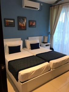 sypialnia z 2 łóżkami i niebieską ścianą w obiekcie Beach Paradise Nilaveli w mieście Trikunamalaja