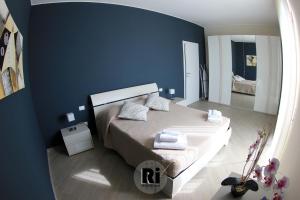 a blue bedroom with a bed and a mirror at Residenze Italia in Sesto San Giovanni