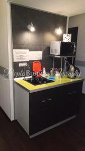 a kitchen with a counter with a stove and a microwave at PEOPLE Business Novinsky Hotel in Moscow