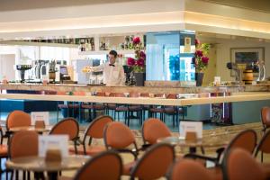 a chef standing behind the counter of a restaurant at htop Molinos Park - Fun in Salou