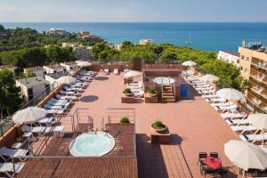 a balcony with a pool and chairs and umbrellas at htop Molinos Park #htopEnjoy in Salou