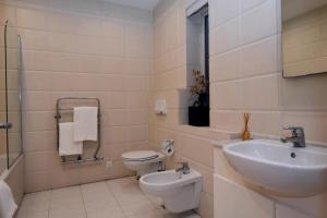 a white bathroom with a sink and a toilet at City Living Suite Tk 3 Rm 4 in St Julian's