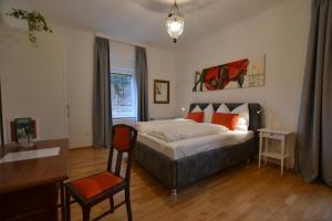 a bedroom with a bed and a desk and a chair at Apartment Graz-Ulrichsbrunn, free parking in Graz