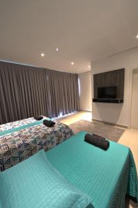 a hotel room with two beds and a flat screen tv at K1 RESIDENCE Campinas in Campinas